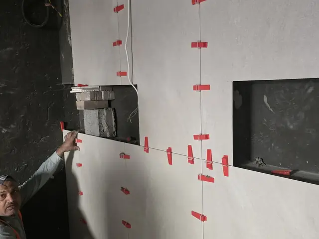 Technician installing large-format wall tiles