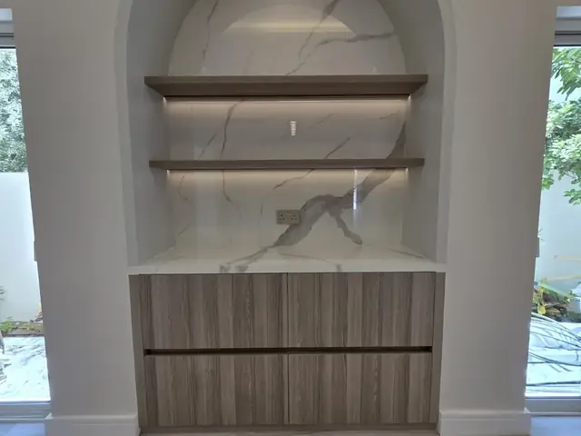 Arched marble display niche with custom joinery and lighting