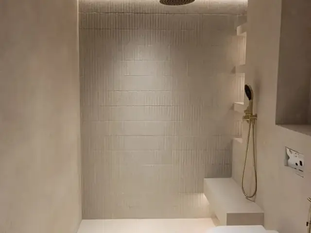 Finished bathroom with brass fixtures and rain shower