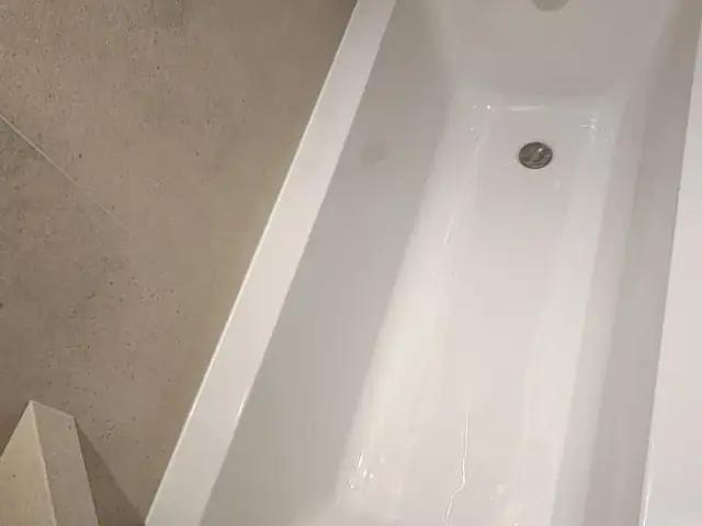 Finished bathtub installation with brass mixer