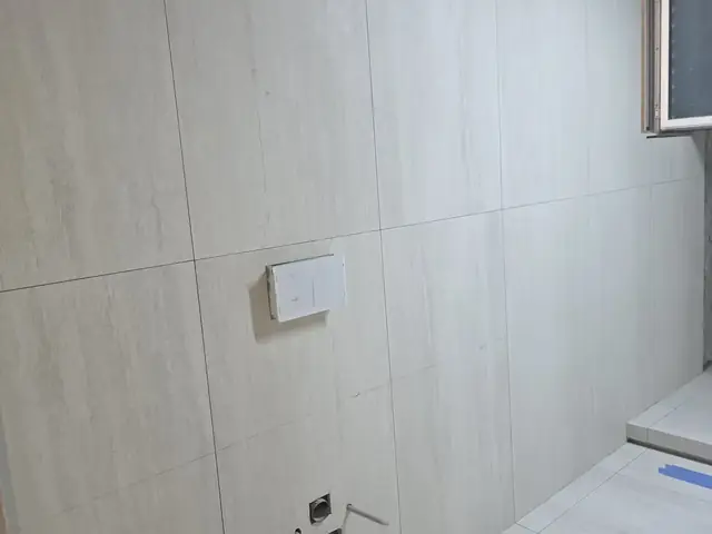 Long bathroom wall tiling with rough-in points