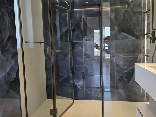 Walk-in glass shower with onyx marble walls
