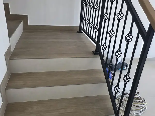 Marble staircase installation with wrought iron railing