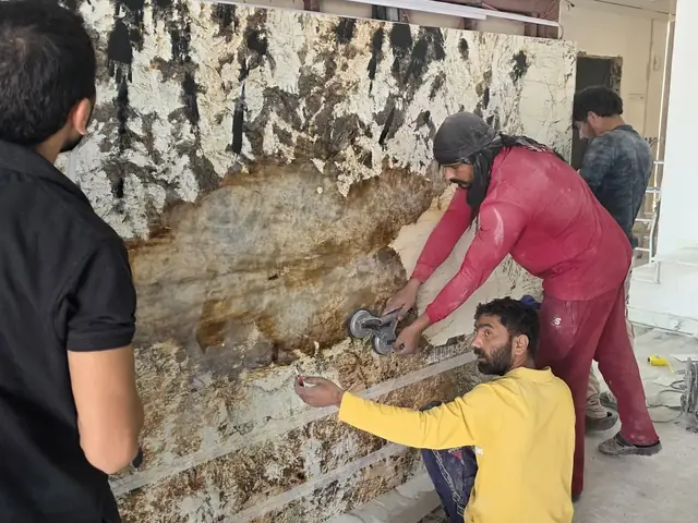 Team installing granite feature wall panel