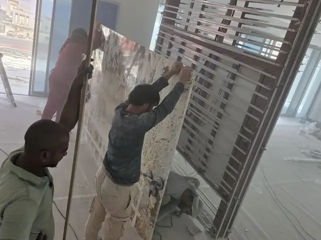 Team fitting large granite slab on site