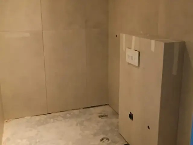 Completed bathroom wall tiling with concealed cistern