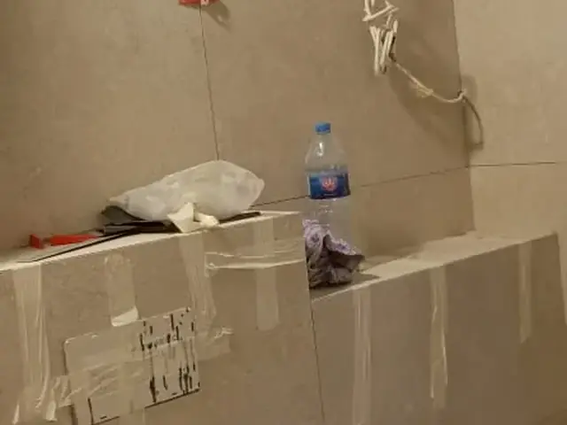 Bathroom floor and wall tiling in progress with leveling clips