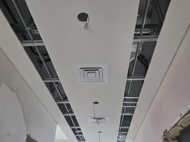 Ceiling AC diffuser and ductwork installation in progress