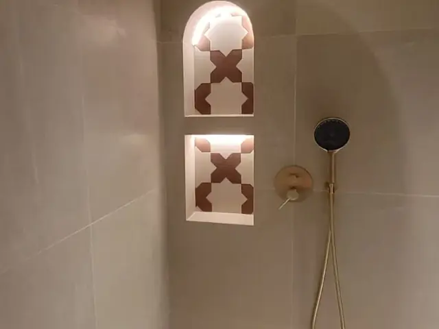 Luxury shower with brass fixtures and Moroccan star tile niche