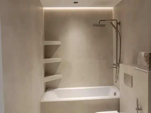 Bathtub bathroom with terrazzo flooring and built-in shelving