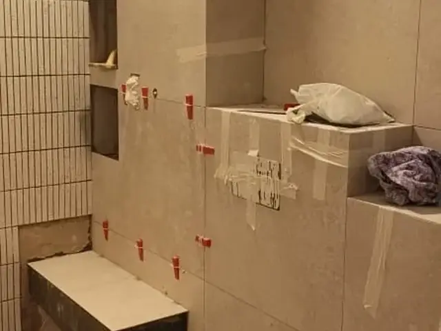 Bathroom tiling with niche shelving and bench seat