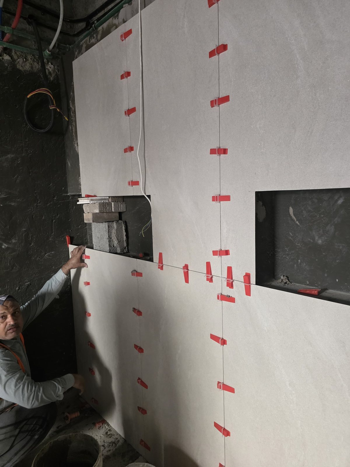 Technician installing large-format wall tiles