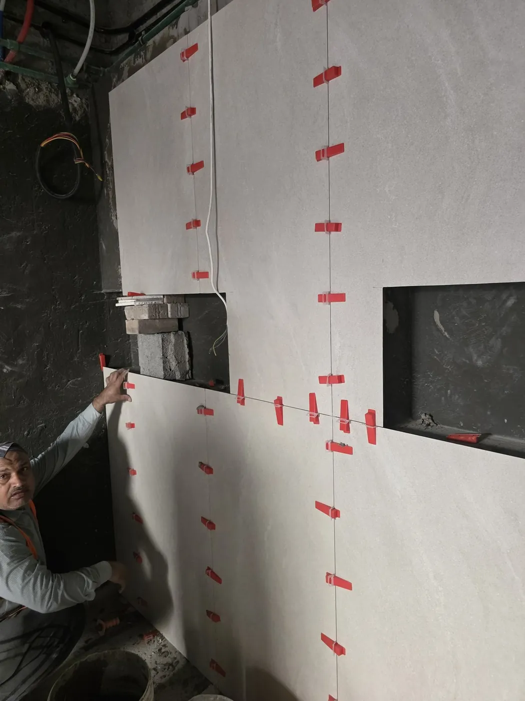Technician installing large-format wall tiles