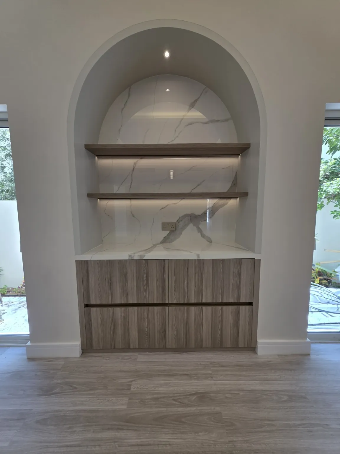 Arched marble display niche with custom joinery and lighting