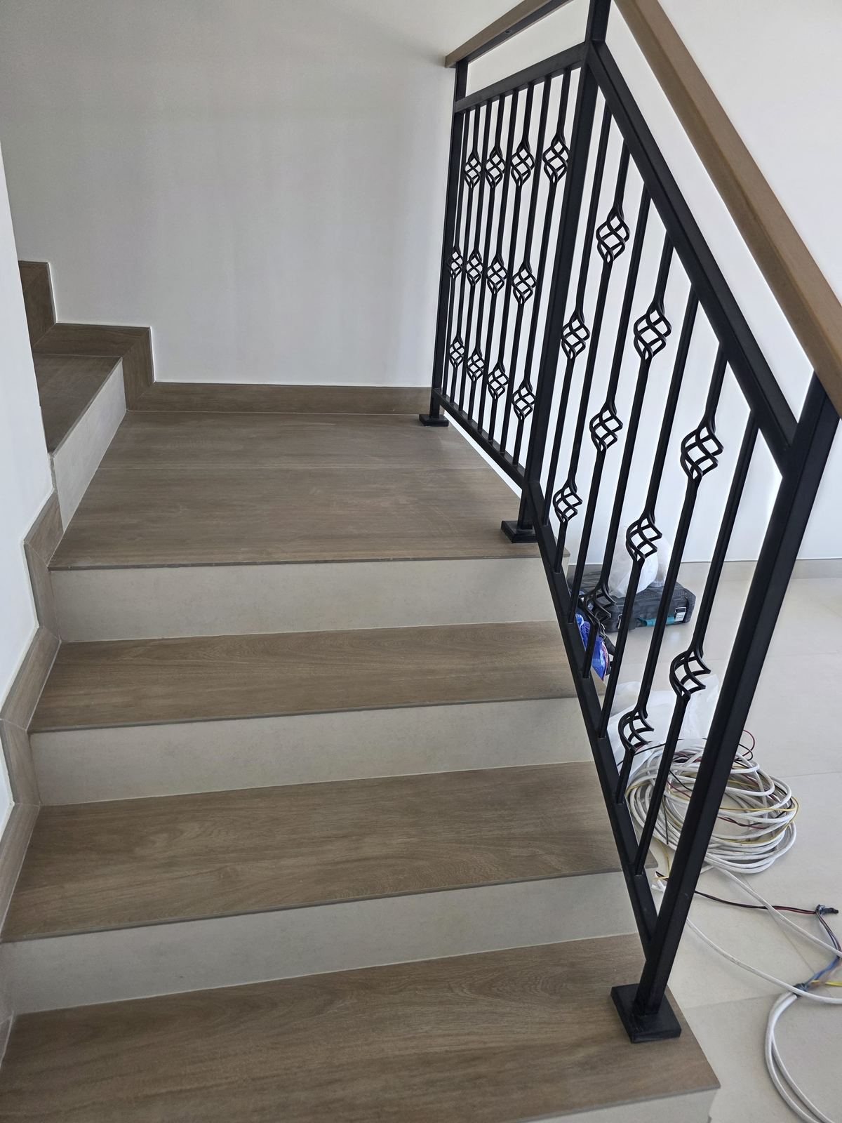 Marble staircase installation with wrought iron railing