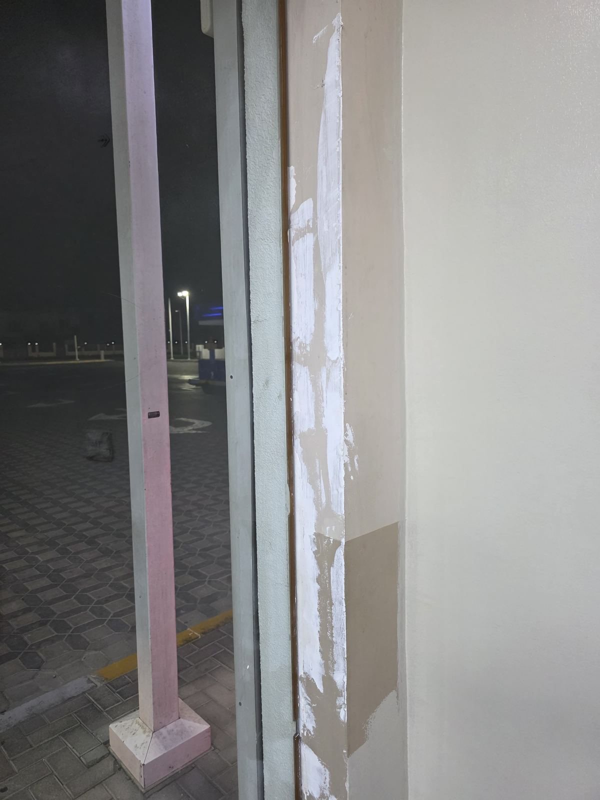 Technician painting ceiling corner at café fit-out