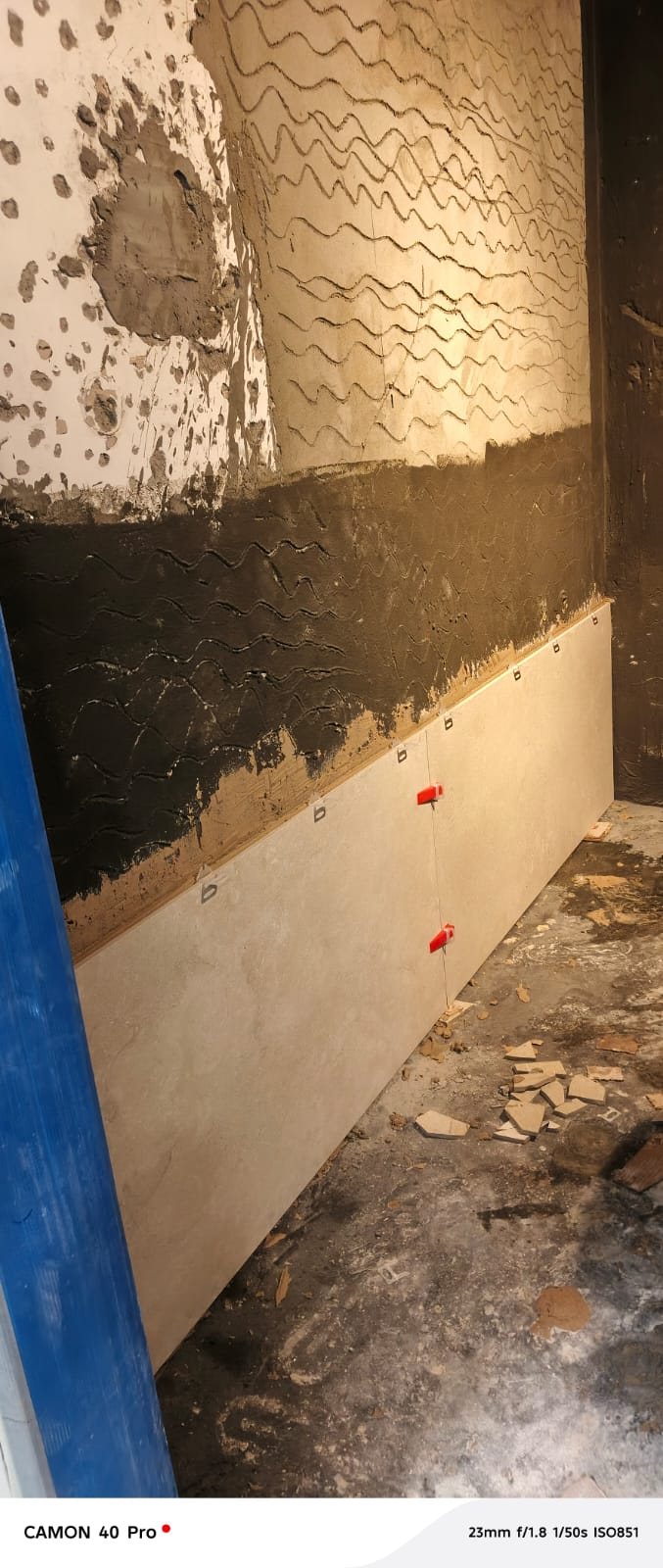 Bathroom wall tiling in progress over waterproofing membrane