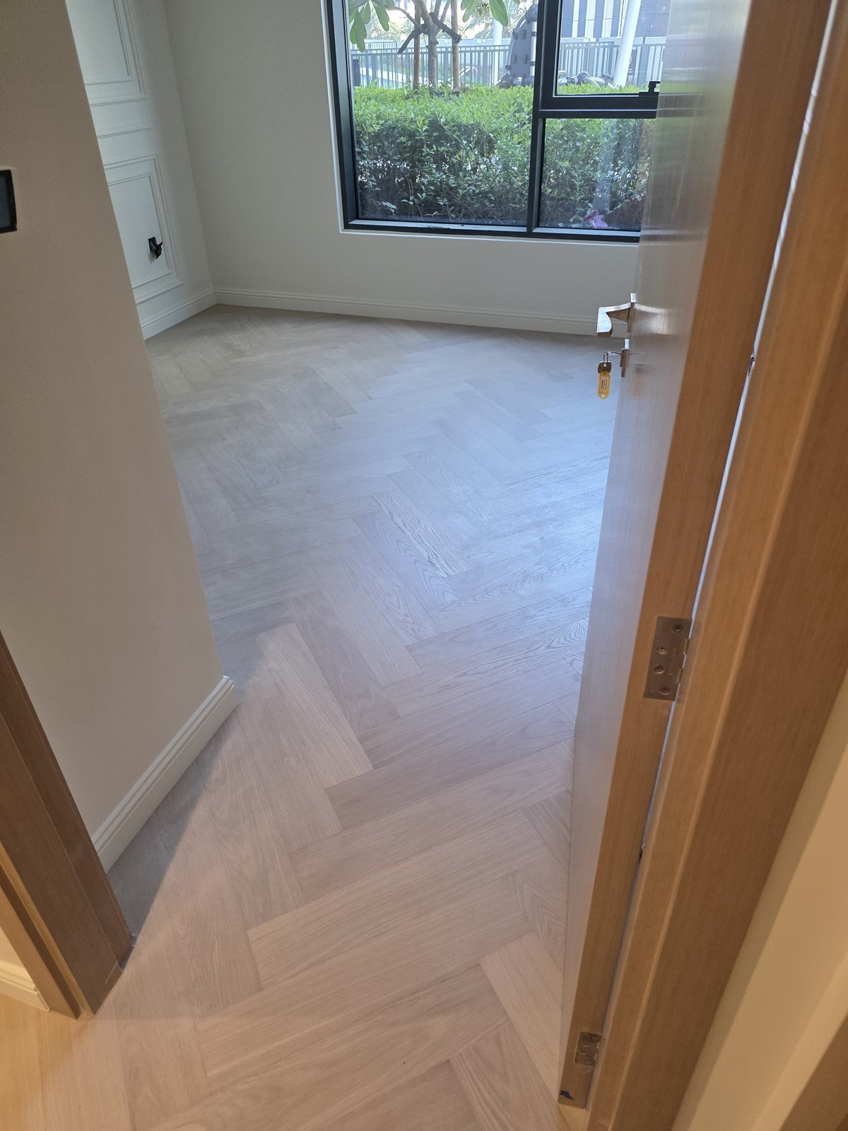 Herringbone parquet flooring installation with garden view