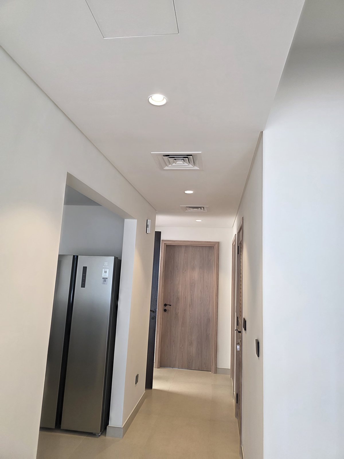 Finished hallway with recessed lighting and AC diffuser