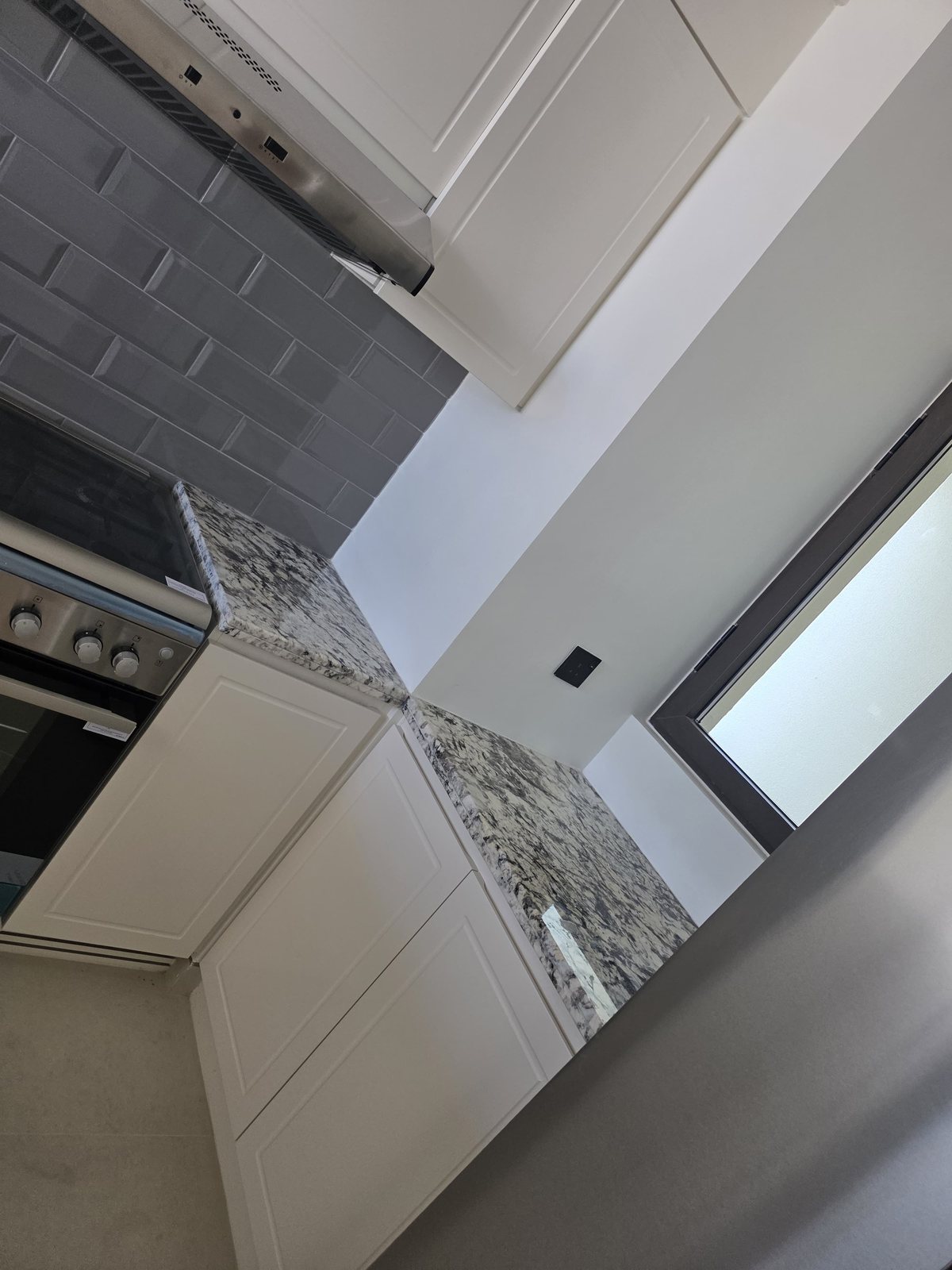 Kitchen cabinetry with granite countertop and extractor hood