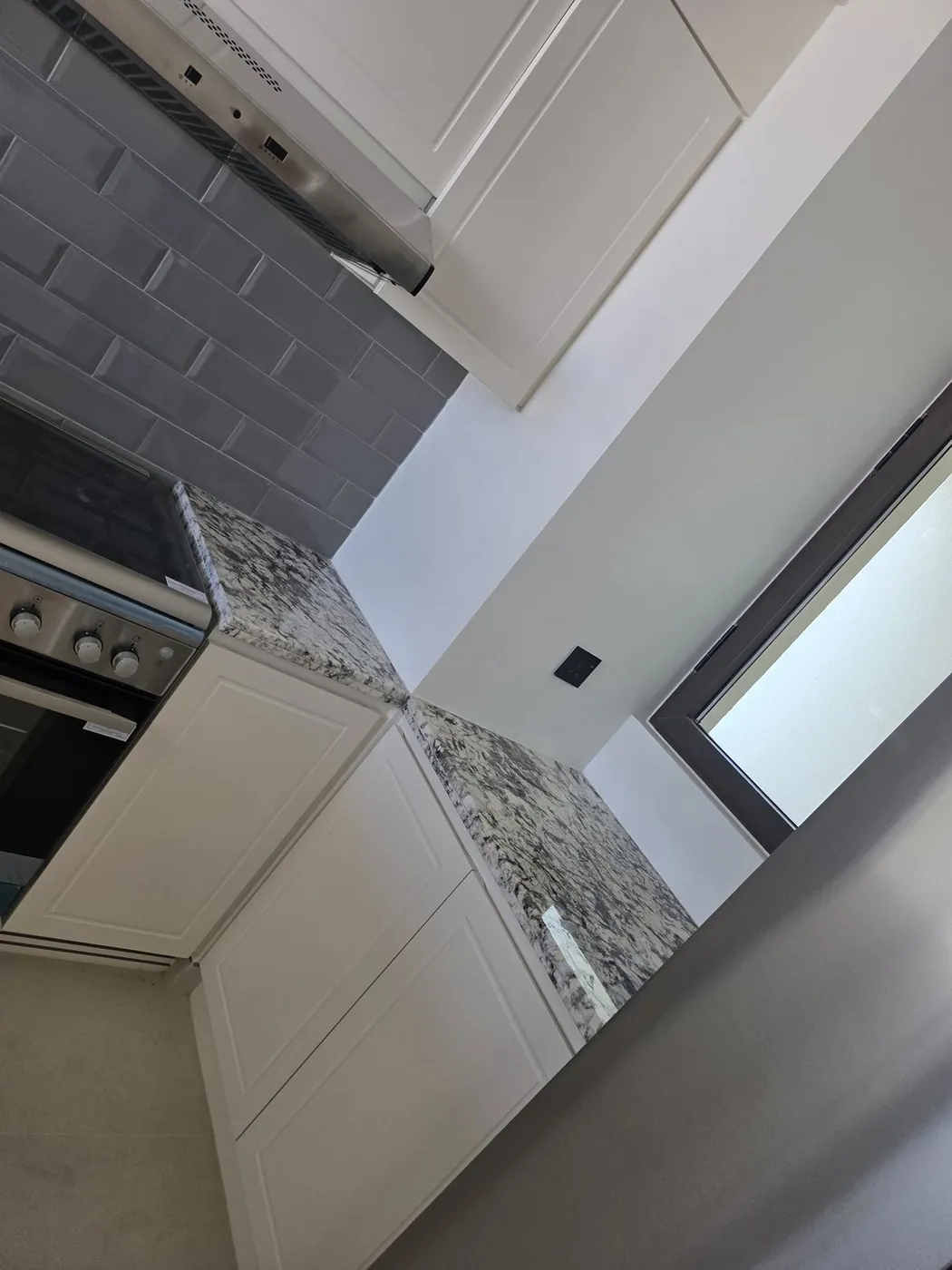 Kitchen cabinetry with granite countertop and extractor hood