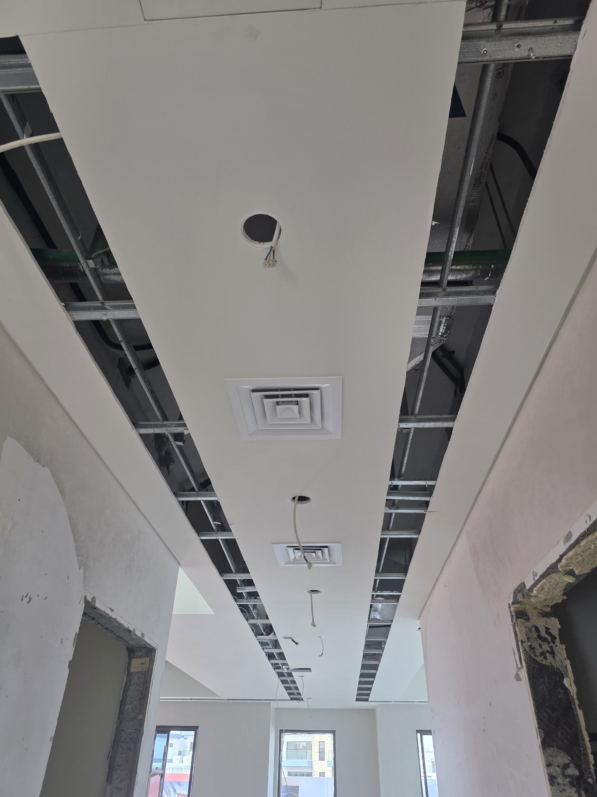Ceiling AC diffuser and ductwork installation in progress