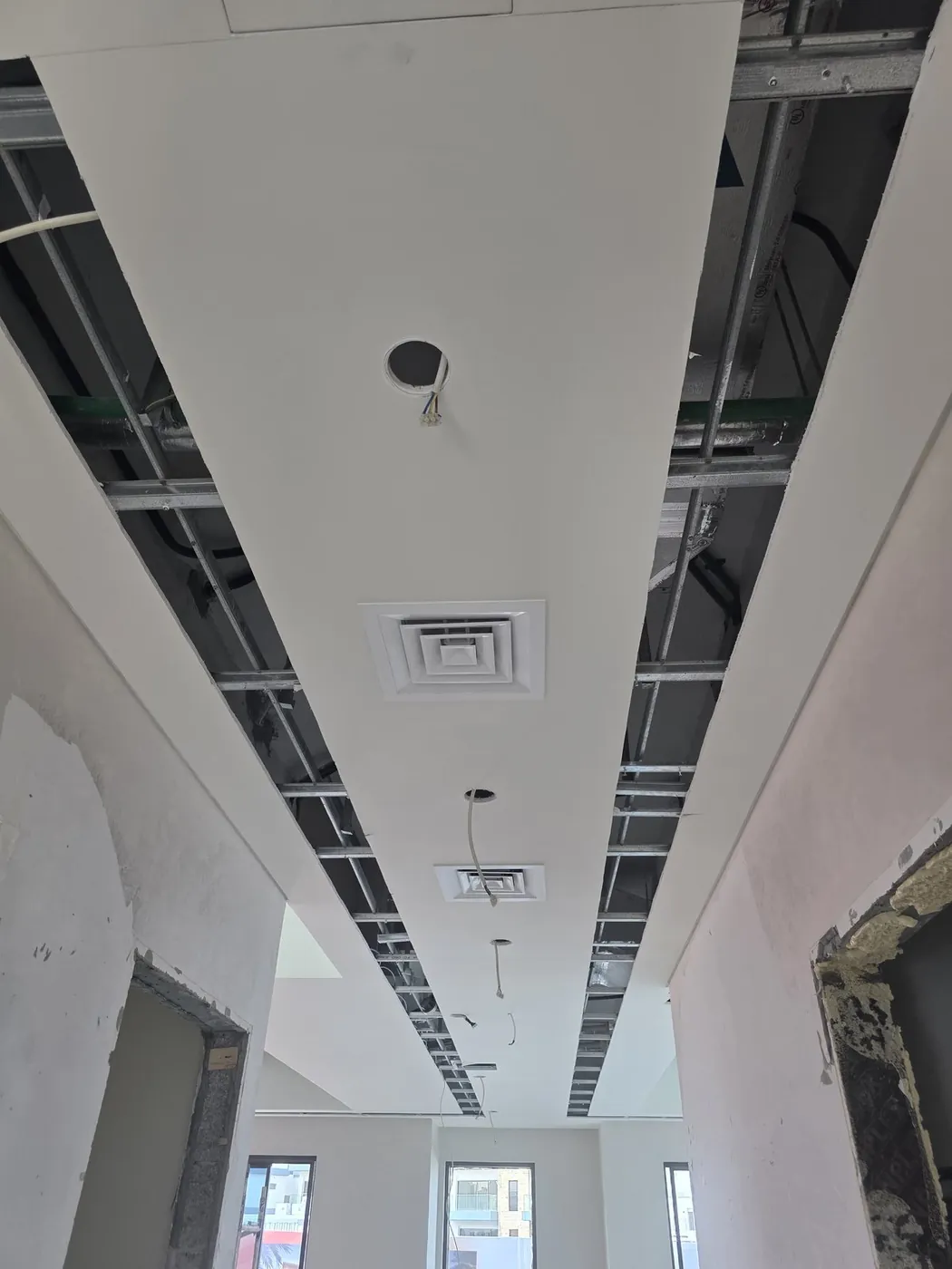 Ceiling AC diffuser and ductwork installation in progress