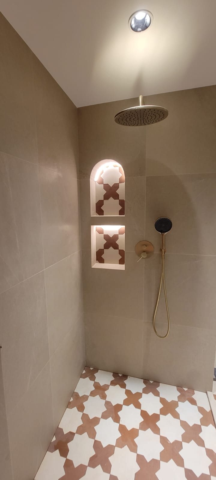 Luxury shower with brass fixtures and Moroccan star tile niche