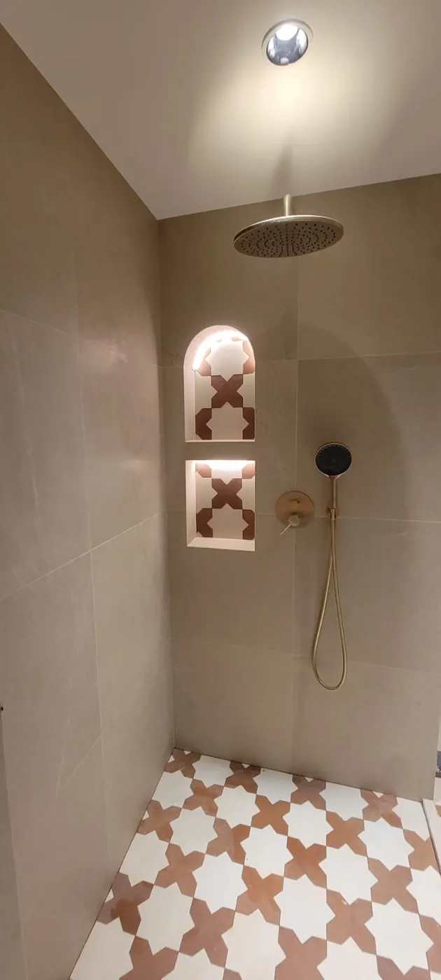 Luxury shower with brass fixtures and Moroccan star tile niche