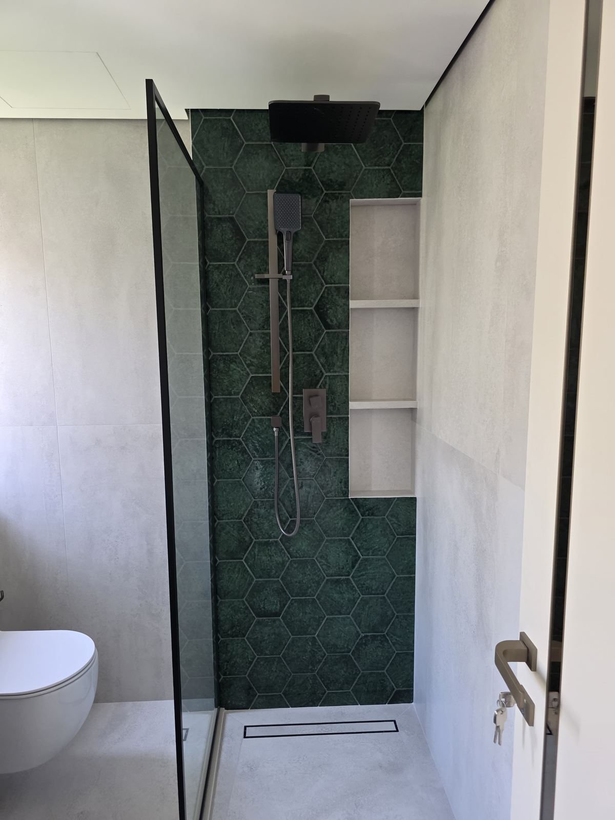 Walk-in shower with hexagon tile and rain shower head