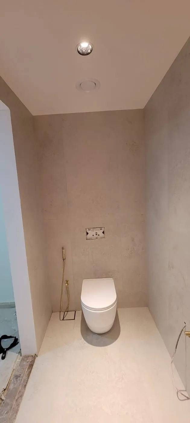 Finished minimalist toilet room with stone-look wall tiling