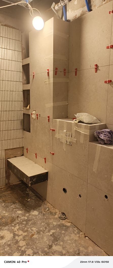 Bathroom tiling with niche shelving and bench seat